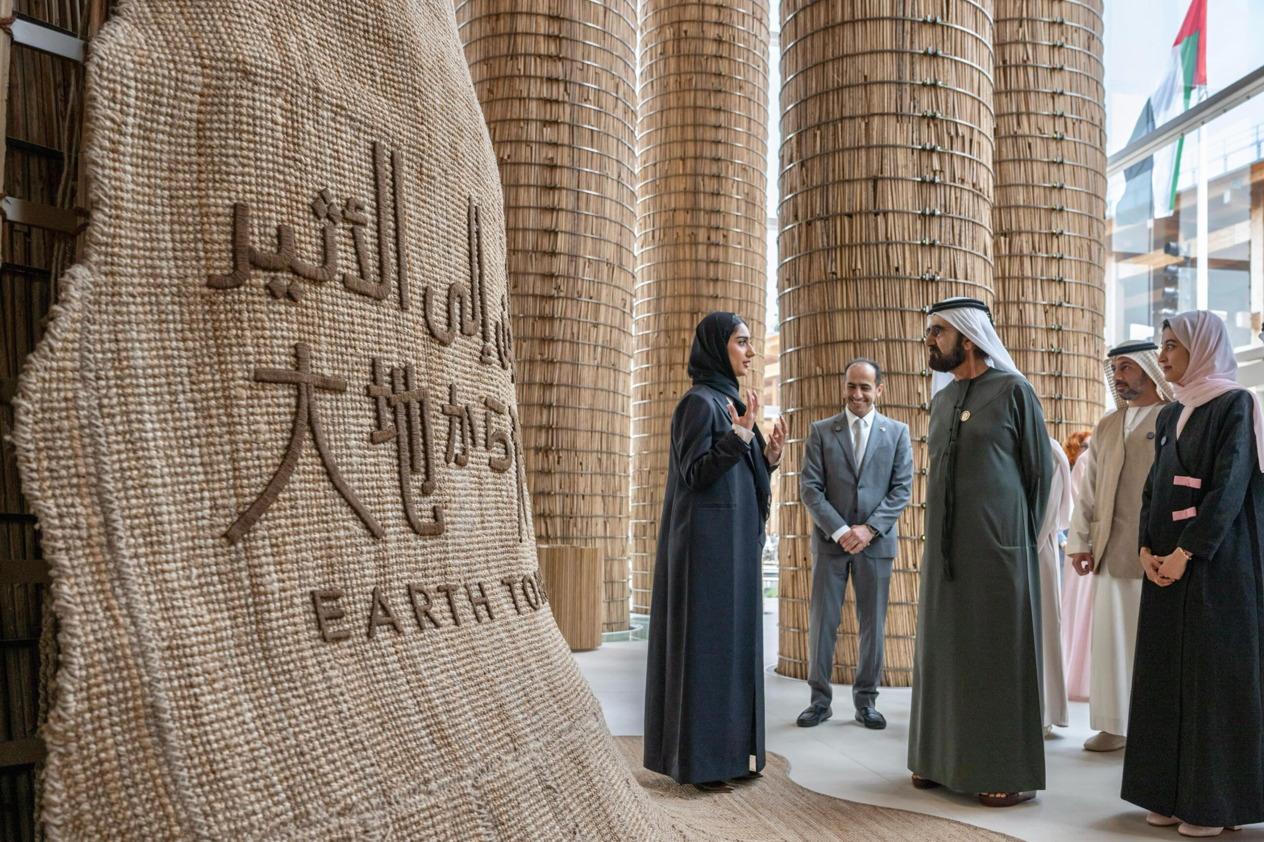 Sheikh Mohammed bin Rashid discussing sustainability with representative near Arabic Earth installation at Osaka exhibition with bamboo architecture